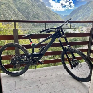 Bicicleta downhill YT Tues 2023 27.5 con horquilla RockShox Boxxer en terraza montañosa